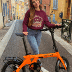 Revolt Carbon Fiber Pro V3, Mid Motor, Belt Drive E-Bike, Orange, Female, Unfolding Adventures Sweater Bordeaux